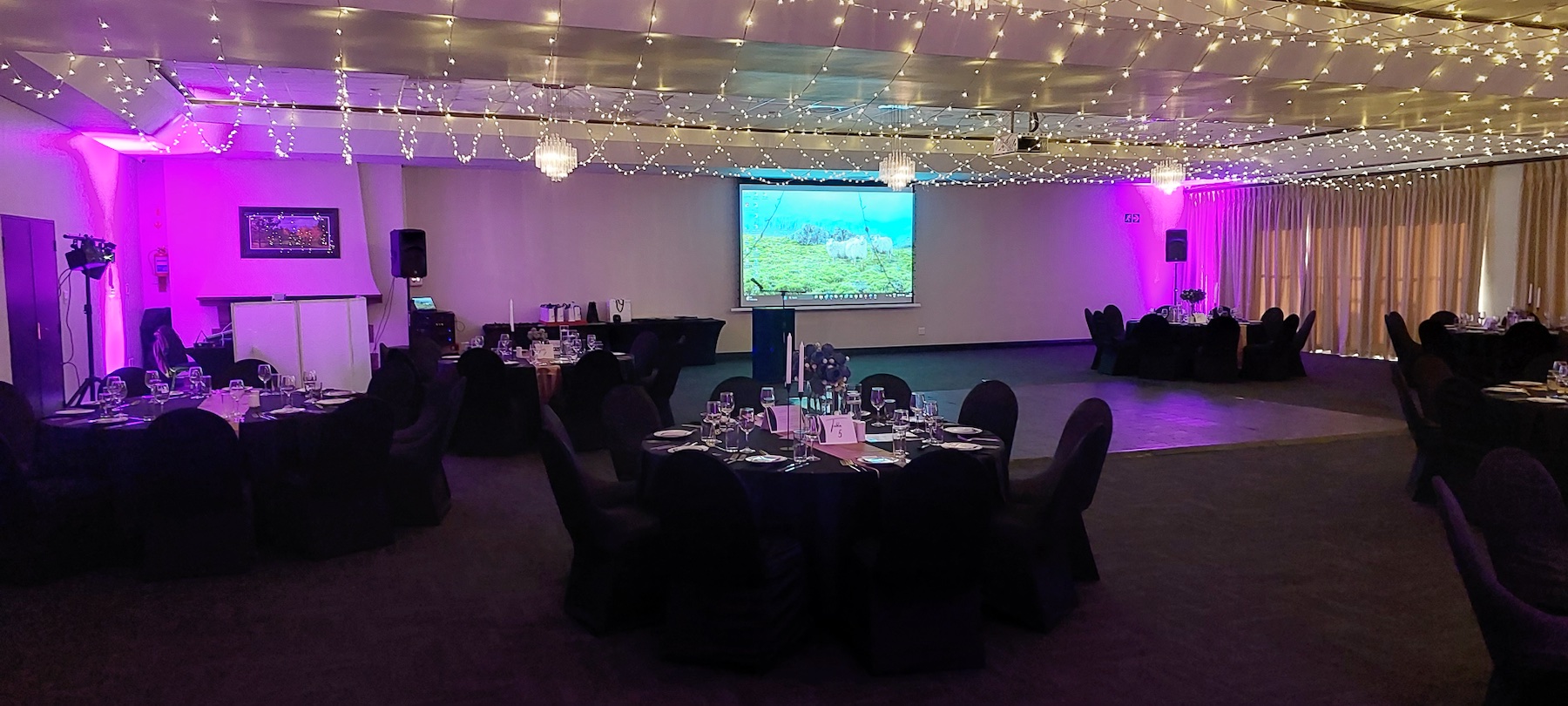 Corporate venue prepared with Entertainworx sound, screens and purple lighting